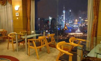 The room features large windows and chairs, providing a view of the city at night from an outdoor dining area at Yuhang Hotel
