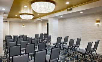 a large conference room with rows of chairs arranged in a semicircle , and a chandelier hanging from the ceiling at The Terrace Hotel Lakeland, Tapestry Collection by Hilton