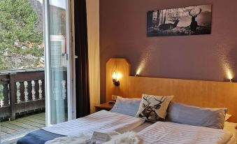 a bedroom with a large bed and purple walls , featuring a window with a view of trees at Hotel am Kurpark