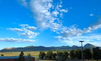a beautiful view of a valley with mountains in the background and clouds in the sky at Ute Mountain Casino Hotel