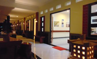 a hotel lobby with a check - in desk and a staircase leading to the second floor at Wisma BPI
