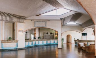 a large , open room with a reception desk and arches is shown in this image at MClub Marmorata