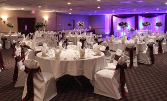 a well - decorated banquet hall with white tablecloths and chairs , ready for a wedding or special event at Clarion Inn Falls Church- Arlington