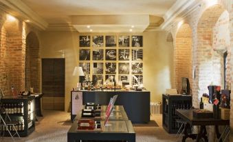 a dining room with a brick wall , a wooden table , and several chairs arranged around it at Castello di Gabiano