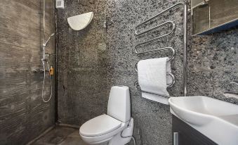 a modern bathroom with a white toilet , sink , and shower area , as well as towels hanging on the wall at Klettar Tower Iceland