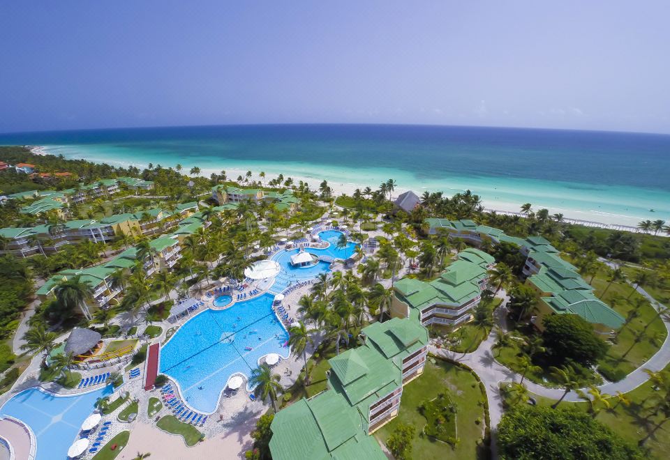 aerial view of a resort with multiple pools and a swimming pool surrounded by palm trees at Tryp Cayo Coco
