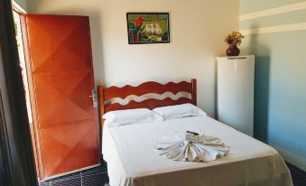a bedroom with a red wardrobe , a bed with white sheets and towels , and a painting on the wall at Hotel Greenville