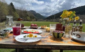 a dining table set with a variety of food items , including fruits , vegetables , and desserts at Farma Sotira