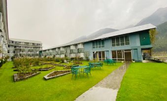 a courtyard surrounded by a building , with several chairs and tables set up for outdoor dining at WoodStock Hotel