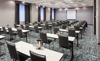 a large conference room with rows of chairs arranged in a semicircle , and a projector screen on the wall at Hampton Inn & Suites Chicago-North Shore/Skokie