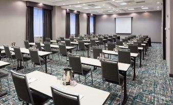 a large conference room with rows of chairs arranged in a semicircle , and a projector screen on the wall at Hampton Inn & Suites Chicago North Shore