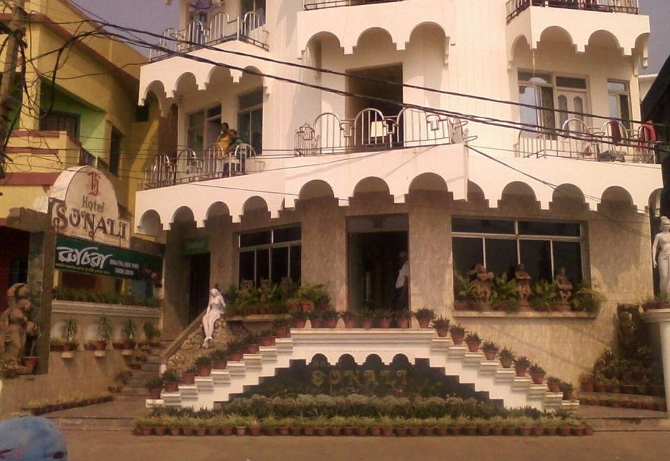 In front of an apartment complex, there is a building with stairs and balconies on the side at Hotel Sonali