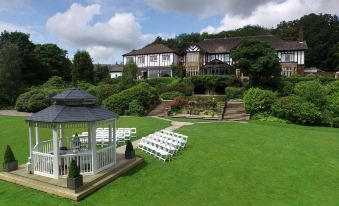 a large house with a gazebo and chairs set up in the front yard of the house at Burnley West Higher Trapp Hotel