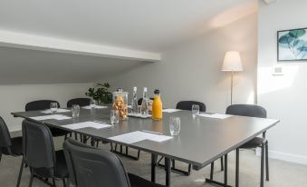 a conference table with a glass bottle of orange juice , glasses , and bottles on it at Hotel la Villa Douce