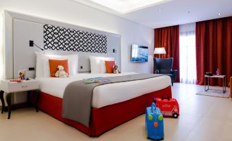 a hotel room with a king - sized bed , a television , and a small toy car on the floor at AX The Palace