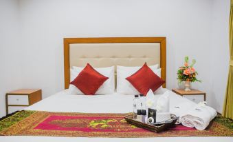 a bed with white sheets and red pillows is shown in a hotel room with a decorative tray on the bed at Mammoth Resort
