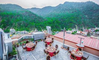 an outdoor dining area with tables and chairs set up for a gathering , surrounded by mountains at Hotel Avenue