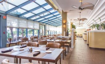 a large dining room with multiple tables and chairs arranged for a group of people to enjoy a meal together at Hilton Melbourne, FL