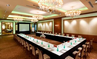 a long dining table set up for a formal event , with multiple chairs arranged around it at Radisson Hotel New Delhi Paschim Vihar