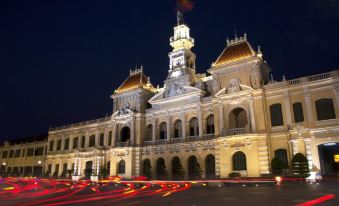 a city scene at night , with a large building illuminated by lights and surrounded by traffic at Alagon Saigon Hotel & Spa