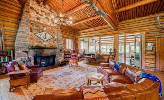 a spacious living room with a large stone fireplace and leather couches , creating a cozy atmosphere at Diamond J Ranch