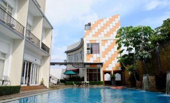 a modern building with a checkerboard pattern is surrounded by a swimming pool and other buildings at Seulawah Grand View