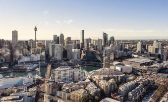 an aerial view of a bustling city with tall buildings , skyscrapers , and a harbor at Novotel Sydney Darling Harbour