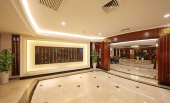 The lobby is clean, well-lit, and features a large marble tiled wall at Seventh Heaven Hotel