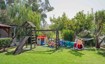 a playground with a variety of play equipment , including swings , a slide , and a jungle gym at Apollo Apartments