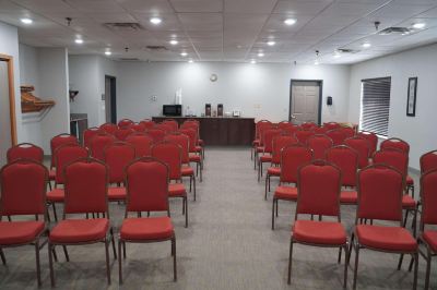 a conference room with rows of red chairs arranged in a semicircle , ready for an event at Country Inn & Suites by Radisson, Watertown, SD