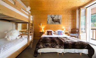 a bedroom with a wooden wall and two beds , one of which has a deer print blanket at Hotel Christiania