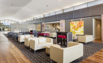 There is a restaurant in the lobby of the hotel, along with other furniture such as tables and chairs at Rydges Resort Hunter Valley, an EVT hotel