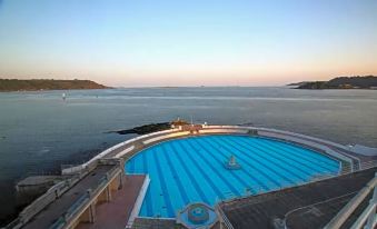 a large blue swimming pool situated on the edge of a cliff overlooking the ocean at The Moorland Hotel