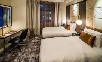 a modern hotel room with two beds , a desk , and a window , all neatly arranged at DoubleTree by Hilton Wellington