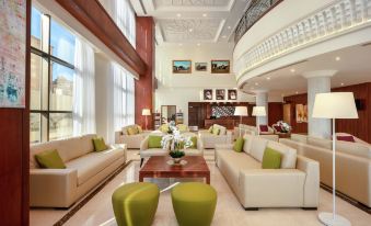a spacious hotel lobby with multiple couches , chairs , and tables , creating a comfortable and inviting atmosphere at Hilton Garden Inn Al Jubail