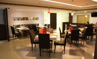 a well - lit dining room with tables and chairs arranged for a group of people to enjoy a meal together at Hotel Midcity