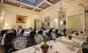 a well - decorated dining room with tables and chairs arranged for a group of people to enjoy a meal at LHotel