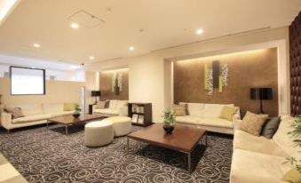 There is a large room with multiple couches and tables located at the far side at Richmond Hotel Tokyo Suidobashi