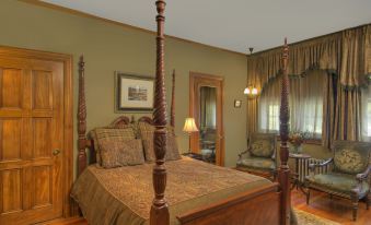 a bedroom with a wooden bed and four - poster bed , two lamps , and a chair at Castle Hill Resort and Spa