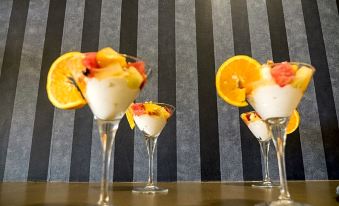 three glasses filled with a white substance and garnished with fruit are placed on a table at Paradise Resort