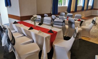 a conference room set up for a meeting , with tables and chairs arranged in rows at The George Hotel