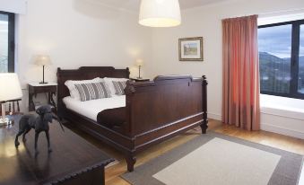a cozy bedroom with a wooden bed , hardwood floors , and a rug on the floor at Quinta Da Marka