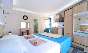 a modern hotel room with a blue and white color scheme , featuring a bed , kitchenette , and dining area at M Suite