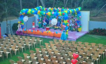 a colorful stage set up for a wedding reception , with chairs arranged in rows for guests at OYO Flagship Hotel Priso