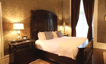 a large bedroom with a king - sized bed , two lamps , and a tv mounted on the wall at The Martha Washington Inn and Spa