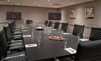 a large conference room with a long black table and multiple chairs arranged for a meeting at Marriott East Lansing at University Place