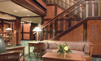 a spacious living room with wooden furniture , including a couch , chairs , and a coffee table at The Craftsman Inn & Suites