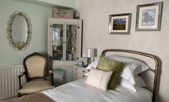 a cozy bedroom with a large bed , white bedding , and a chair near the window at Evangelisa