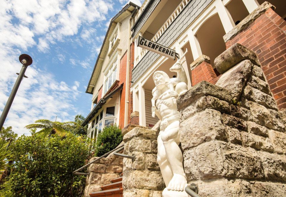 "a statue of a man is standing in front of a building with the sign "" clemenger bbdo "" above it" at Glenferrie Lodge