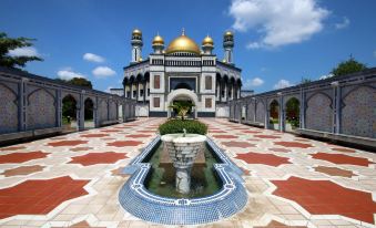 a large , ornate building with a fountain in the center is surrounded by tiled walkways at Mulia Hotel